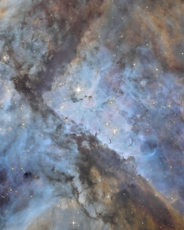 青白く光るガスの中のイータ・カリーナと、斜めに走る暗いちりの帯 / Eta Carinae in pale blue glowing gas, with dark lanes of dust running diagonally