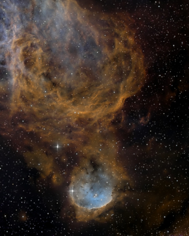 銅色のガスの殻の下にある、縁の明るい丸い星雲NGC 3324 / The round, bright-rimmed nebula NGC 3324 below shells of copper-coloured gas